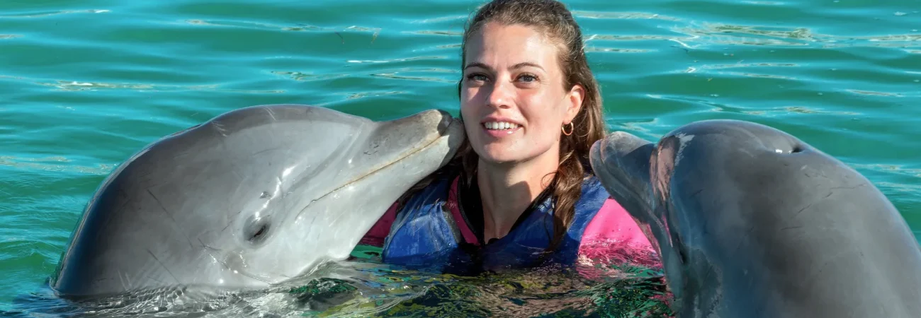 Dubai Dolphinarium - Dolphins kiss young woman