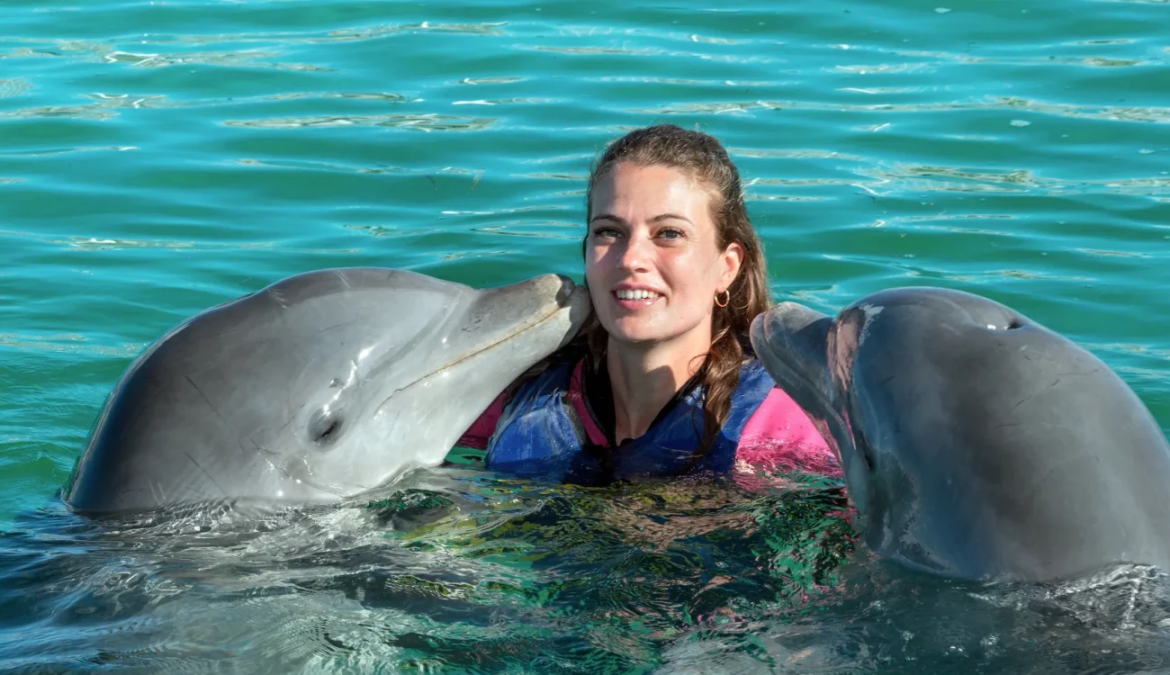 Dubai Dolphinarium - Dolphins kiss young woman